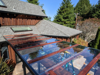 An above shot of a pergola with dark-stained wood and glass